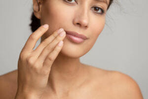 Femme caresse son visage avec mains douces - Paonia Blu Particuliers anti-calcaire ULF Paonia adoucit les mains avec aragonite